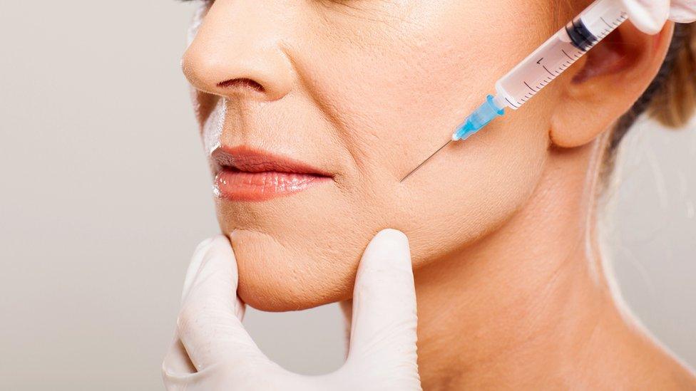 A woman receiving an injection near to her mouth