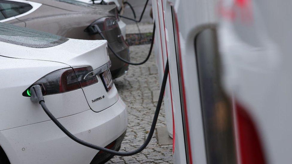 Tesla electric cars charge at a Tesla charging station