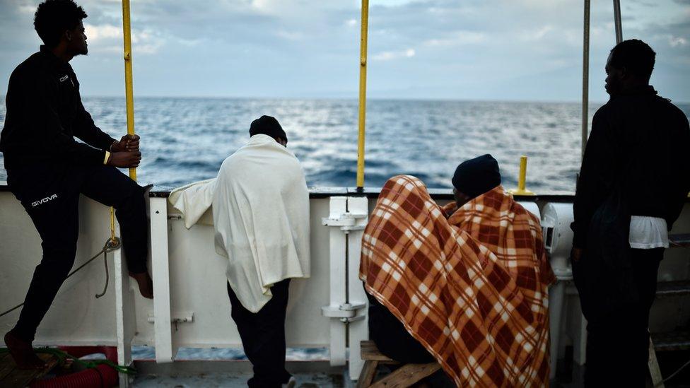 Migrants looking out to sea