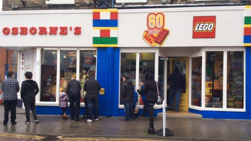 People gather outside Osborne's toy shop in Rusden to see its frontage covered in Lego.