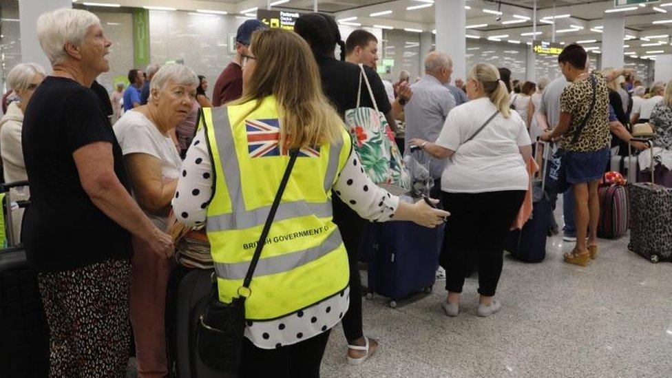 British Government officials help Thomas Cook passengers at Palma the Mallorca airport