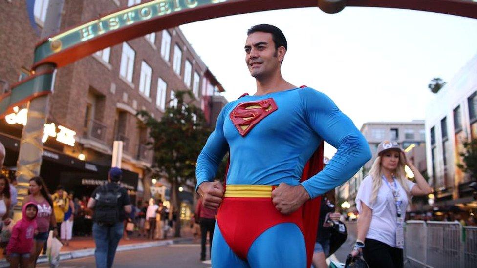 A Cosplay character dressed as Superman, poses for pictures along 5th Avenue in the Gaslamp Quarter during Comic Con International on July 20, 2017 in San Diego