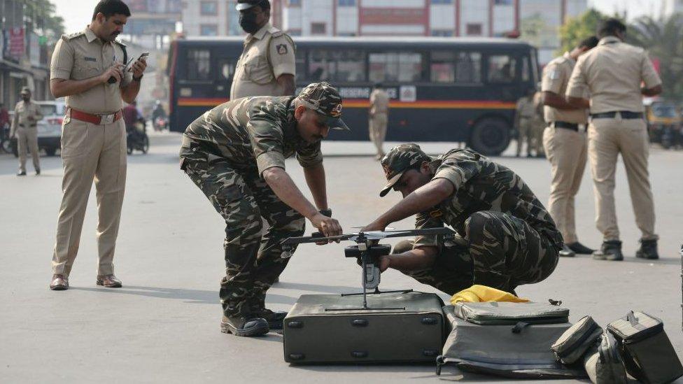 A police surveillance team prepares to fly a drone in Shimoga, Karnataka on February 23, 2022, following violence that broke out