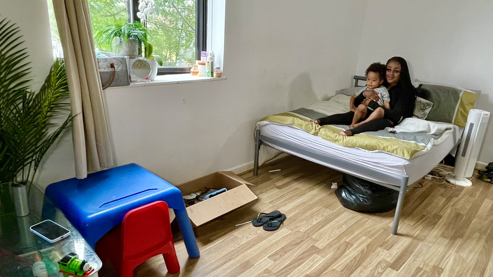 Belinda Muma and her son on a bed watching television