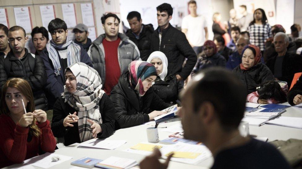 Refugees from different countries attend an information event at a new jobs counselling centre for migrants and refugees at former Tempelhof Airport on 26 February 2016 in Berlin