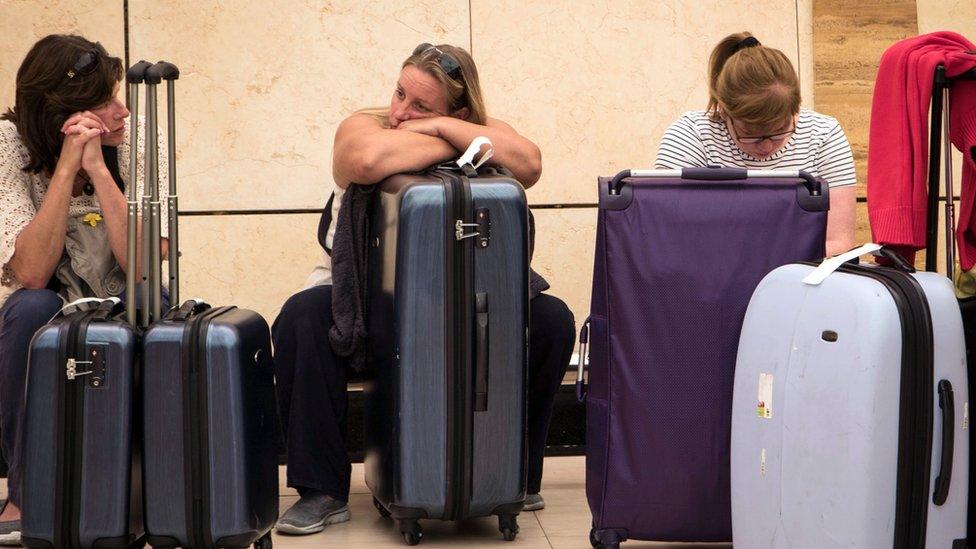 Tourists wait with luggage at Sharm el-Sheikh airport