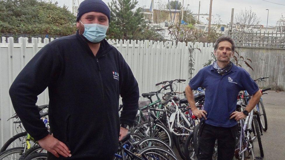 Southern's Dylan Lohman (left) delivers 25 left-behind bikes to Bicycle Technician Paul Horta-Hopkins at SCDA's Newhaven recycling workshop