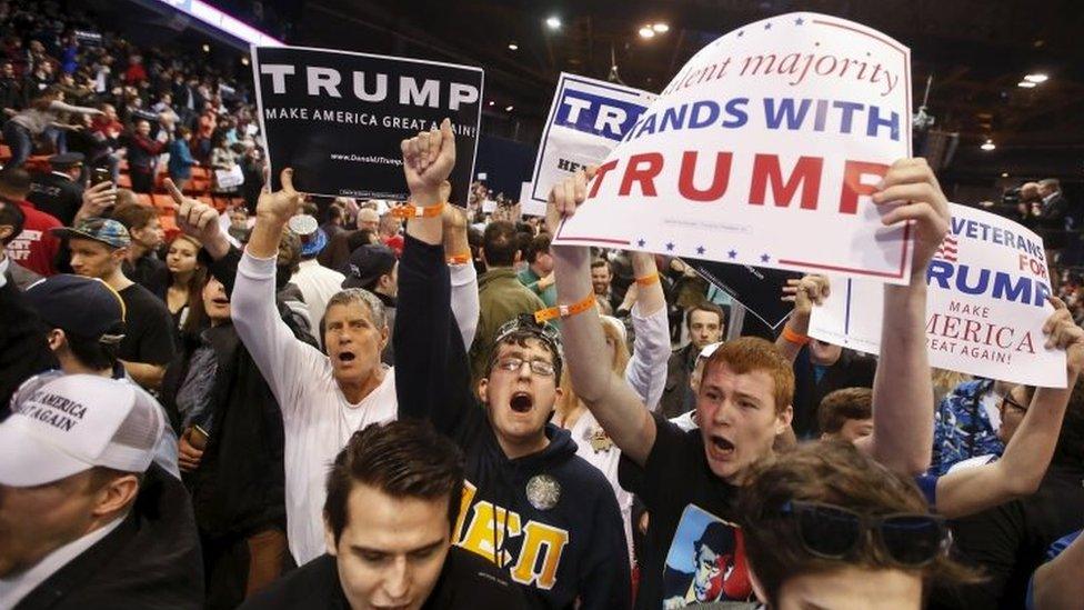 Trump supporters hold signs after Republican US presidential candidate Donald Trump