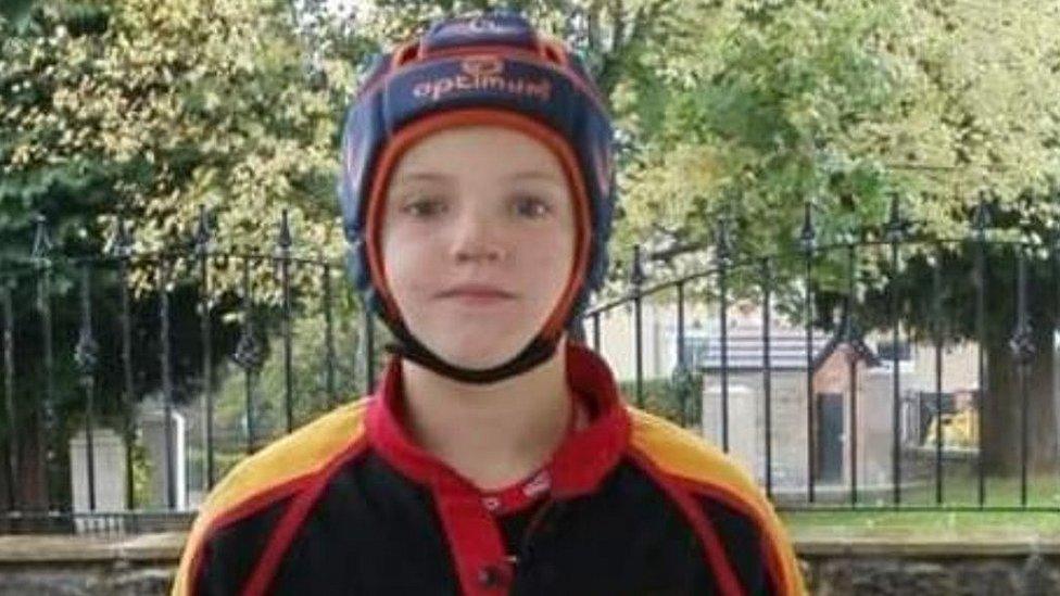 Rhydian in a rugby shirt and protective helmet