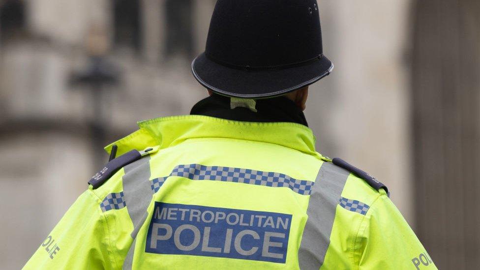 An image of the back of a Metropolitan Police officer in a hi-viz jacket