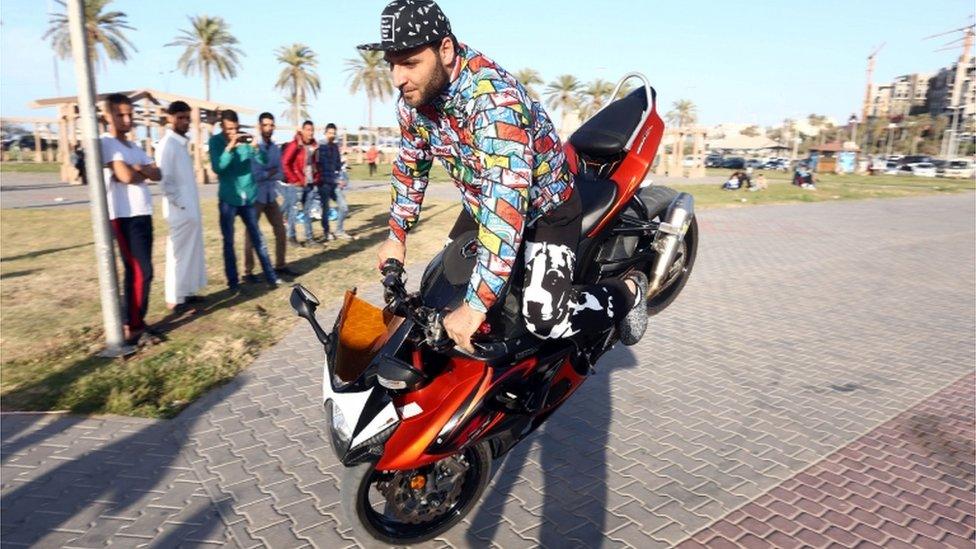 A Libyan motorcyclists performs a stoppie, or a front wheelie, in the capital Tripoli on 8 April 2016