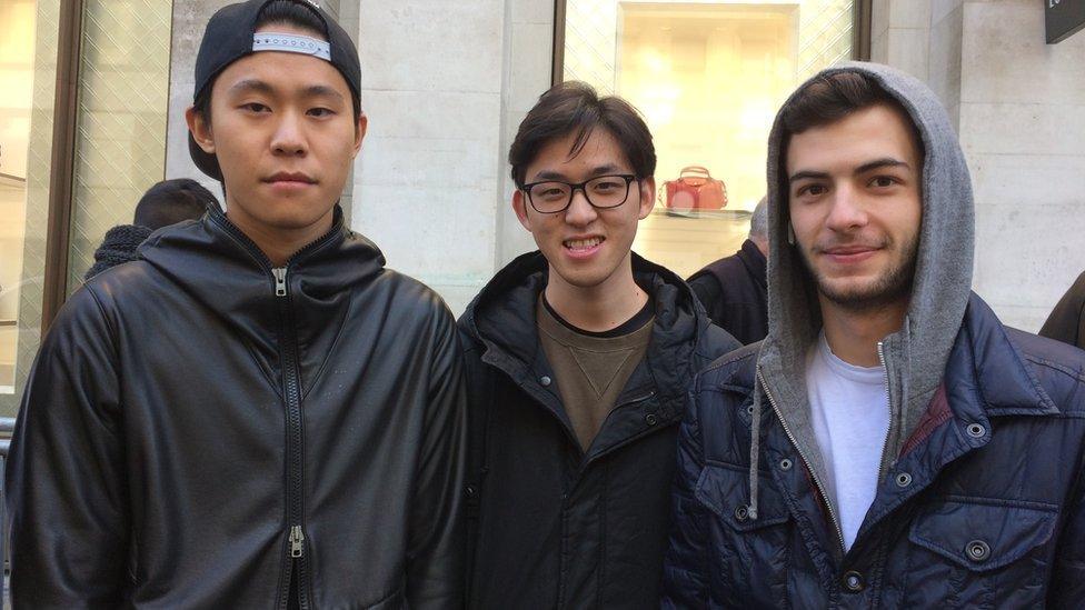 Three men queue for the iPhone X