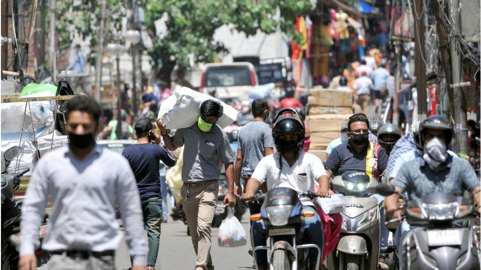 A rush of people and motorists in a marketplace area as shops start opening in the city under specific guidelines, on May 20, 2020 in Jammu, India