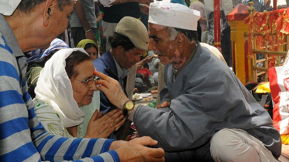 A Hindu priest applies a religious mark on the forehead of an Indian Kashmiri Hindu (Pandit) devotee during the annual Hindu festival at the Khearbhawani temple in Tullamulla village, some 30 kms east of Srinagar on May 29, 2012.