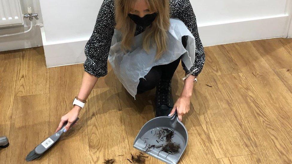 Woman sweeping hair from the floor