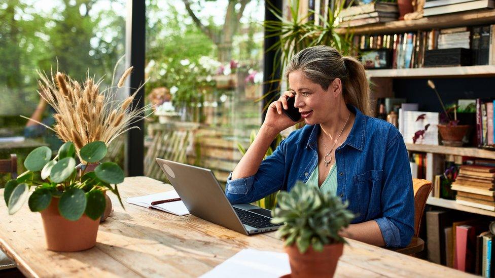 Woman working on a laptop from a dining table