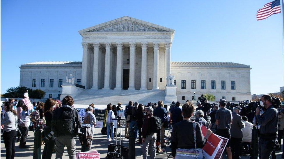 Demonstrators and reporters gather in front of the US Supreme Court in Washington, DC