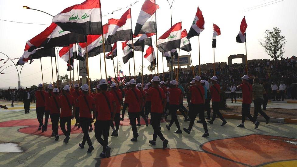 Flags are held aloft by marchers in the parade