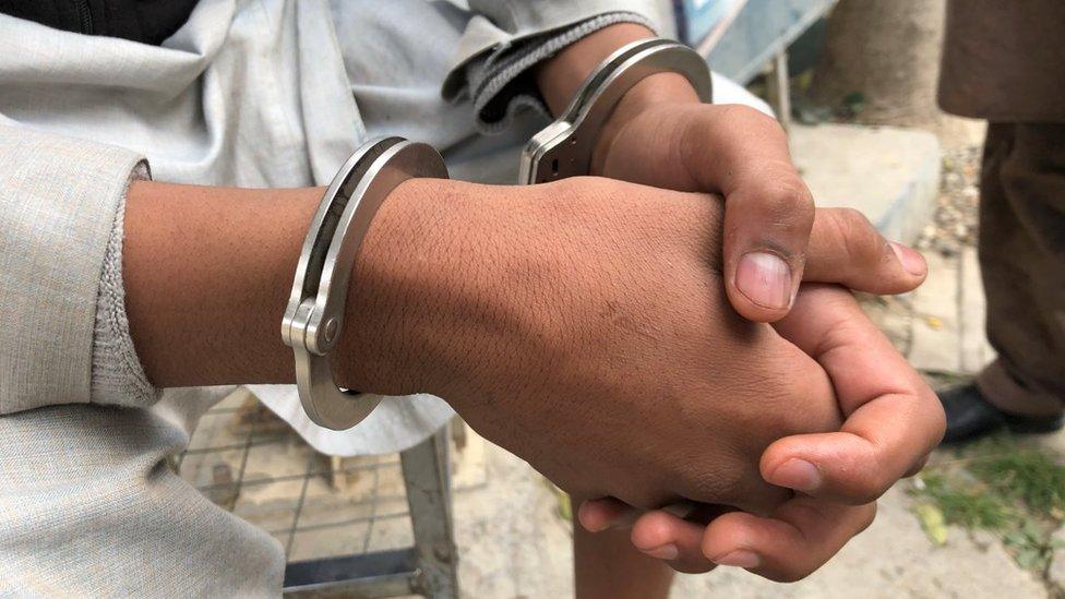 A boy's hands in handcuffs