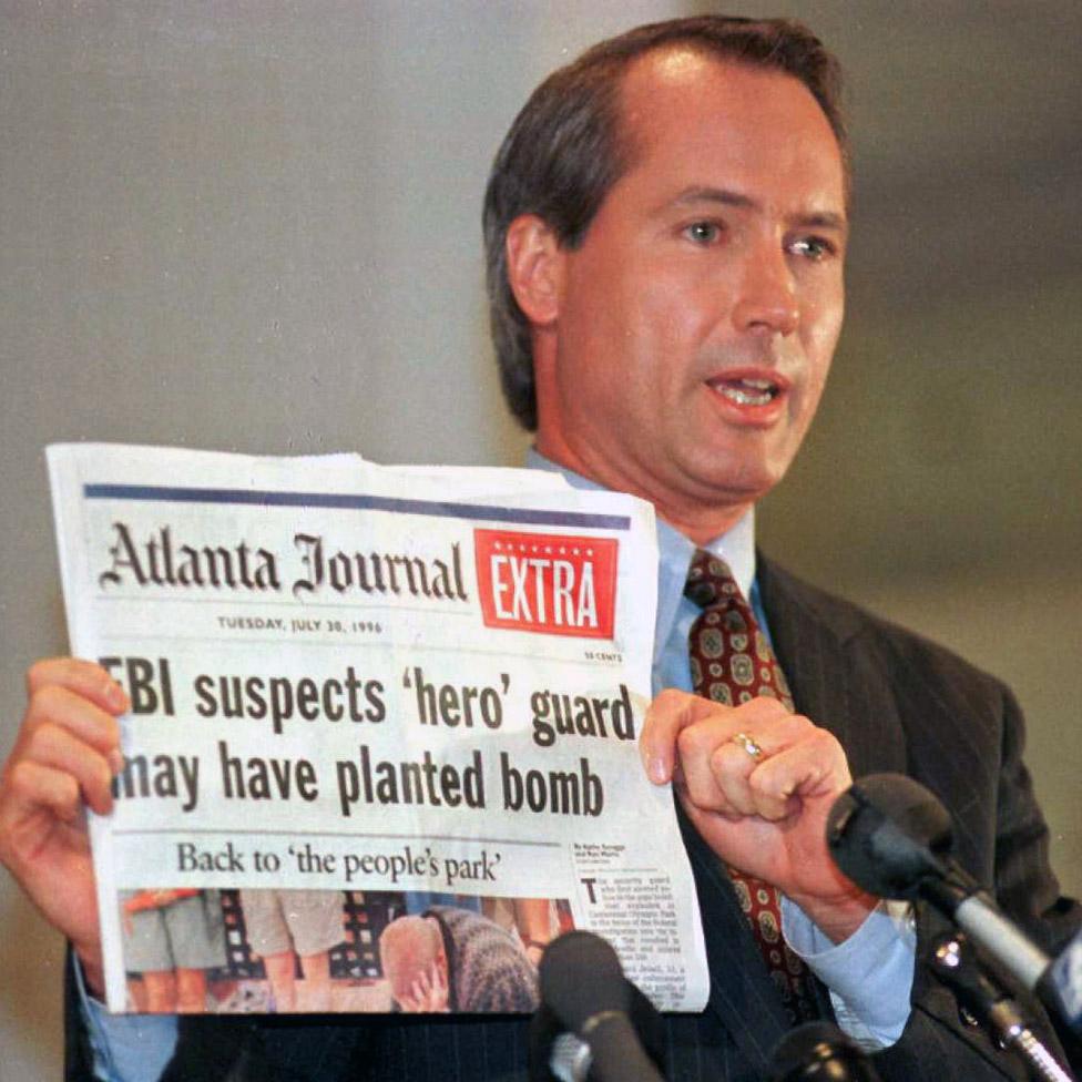 Richard Jewell attorney Lin Wood holds a copy of the Atlanta Journal during a press conference in 1996