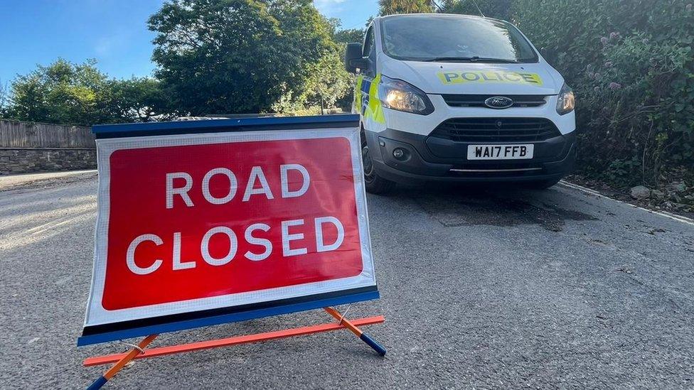 Road closed sign and police van