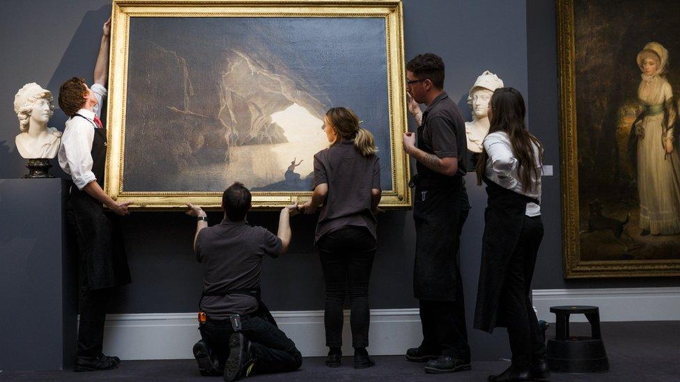 Technicians install the Joseph Wright painting at Sotheby's in London