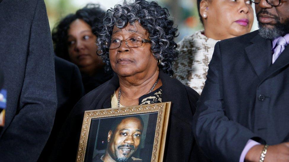 Judy Scott listens while holding a photo of her son Walter Scott during a news conference