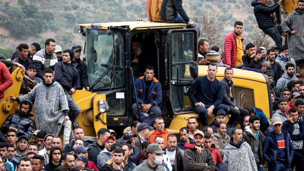 People watch as Moroccan emergency services teams work on the rescue of five-year-old boy Rayan from a well shaft he fell into