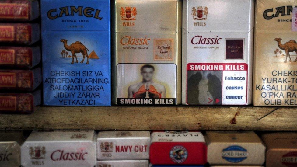 A packet of cigarettes (C), adorned with an image said to resemble that of Chelsea and England footballer John Terry, stands on a stall in New Delhi on January 3, 2012