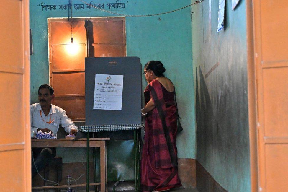 A woman casts her ballot at a polling station during the third phase voting in India's general election, in Guwahati on May 7, 2024. (