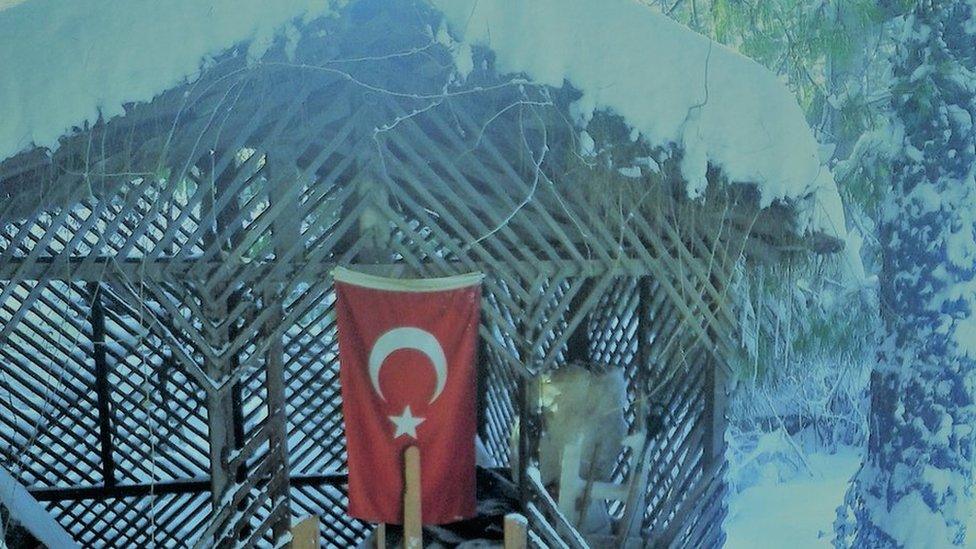 Turkish flag hanging on snow covered summer house