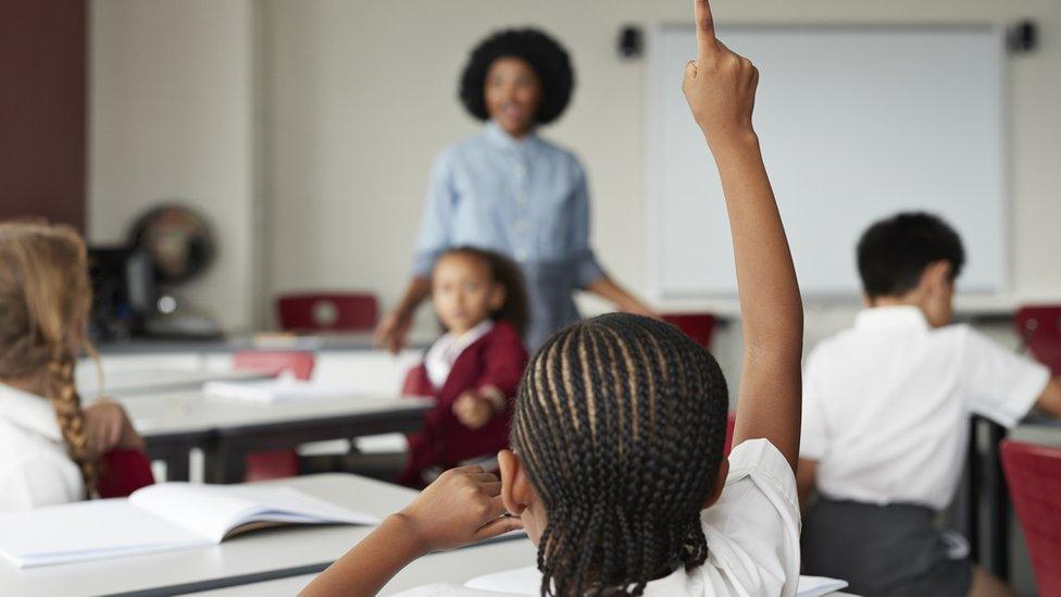 child-raises-hand-in-classroom