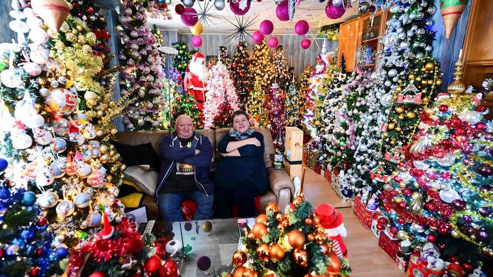 Susanne and Thomas Jeromin, the official world record holders with their 555 decorated Christmas trees in one home, pose for a photo in their living room in Rinteln, west of Hanover, Germany.