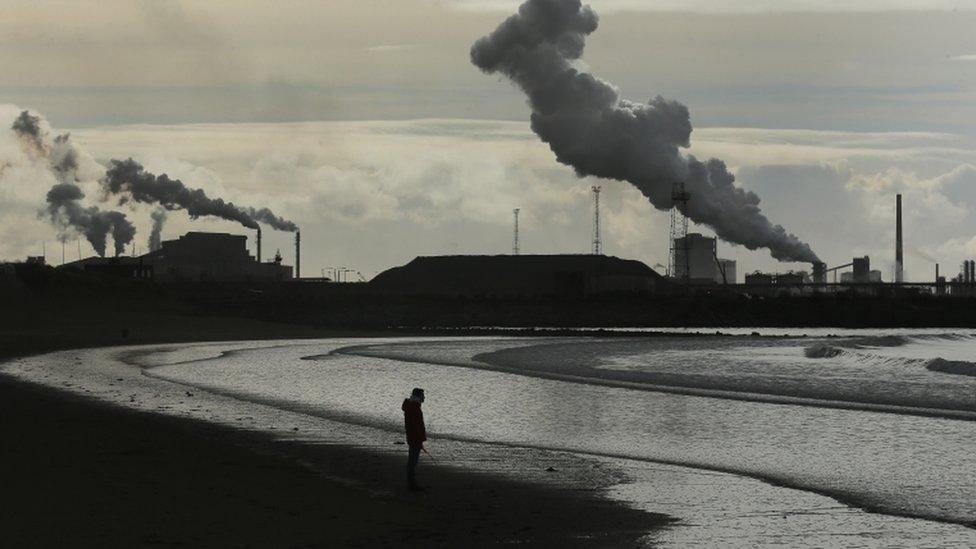 Man on beach by Port Talbot steel plant