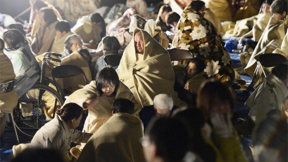 Residents take shelter outside the town hall of Mashiki, near Kumamoto city, southern Japan, after the earthquake early Friday, April 15, 2016.