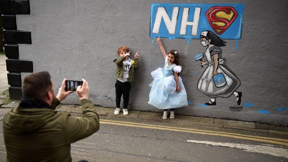 Children having their photo taken by graffiti