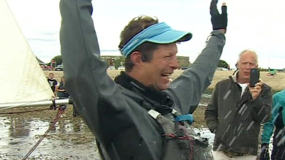 Dr Andrew Hill-Smith celebrating on the beach at Stokes Bay