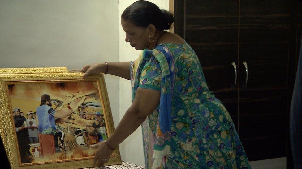 A photo of one Gurmeet Ram Rahim Singh's followers holding a painting of him.