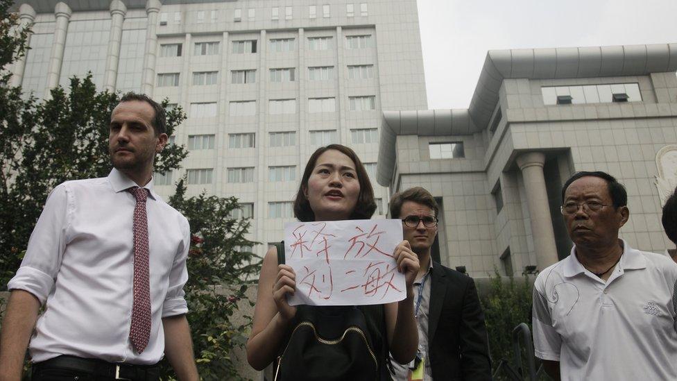 Around two dozen supporters of a prominent Chinese human rights lawyer and three activists charged with subversion protested outside the northern city court amid widespread concerns that authorities were holding their trials in secret