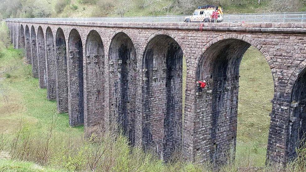 Rescuer abseiling on viaduct