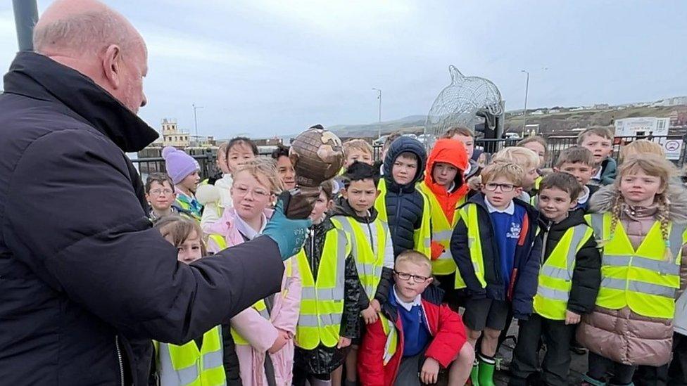 Bill Dale showing the Energy Globe award to pupils