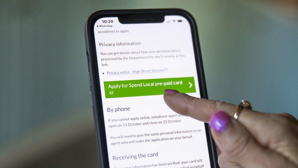 A woman using a web browser on her mobile phone to apply for the Spend Local voucher