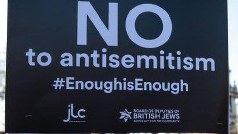 Protestors holding signs reading "no to anti-Semitism #enoughisenough"