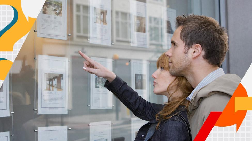 Couple looking in estate agent's window