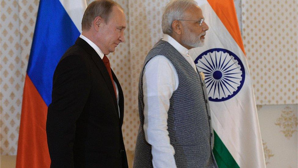 India Prime Minister Narendra Modi (R) gestures as he speaks with Russian President Vladimir Putin during the exchange of agreements and joint press statements ceremony at Taj Exotica hotel in Goa on October 15, 2016