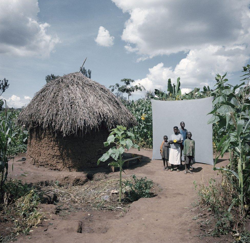 A family stand next to their house.