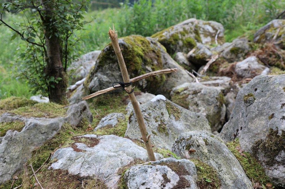 Wooden cross by some rocks