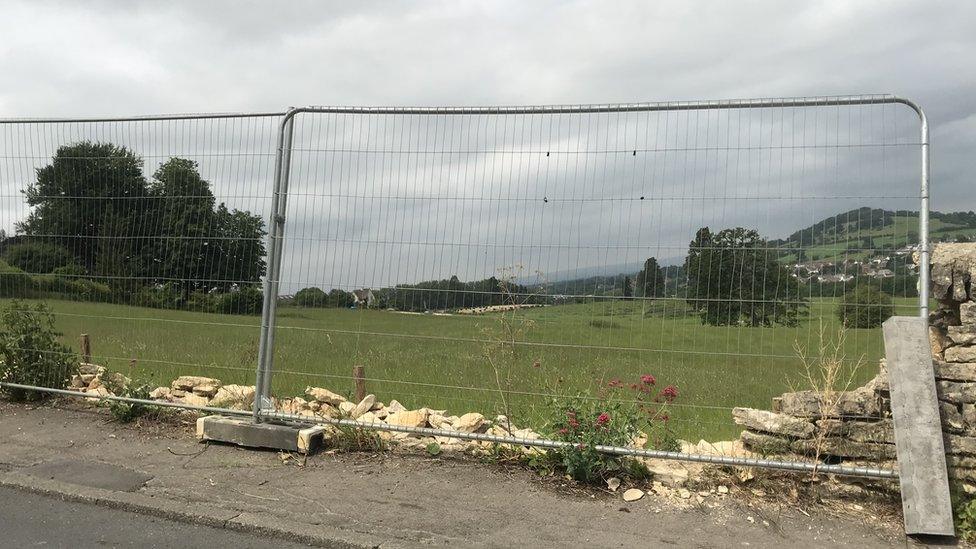 The collapsed wall, with a metal fence before the repairs were carried out