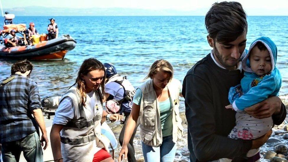 Migrants are helped by rescuers as they arrive on the Greek island of Lesbos after crossing the Aegean Sea from Turkey, 16 September 2019