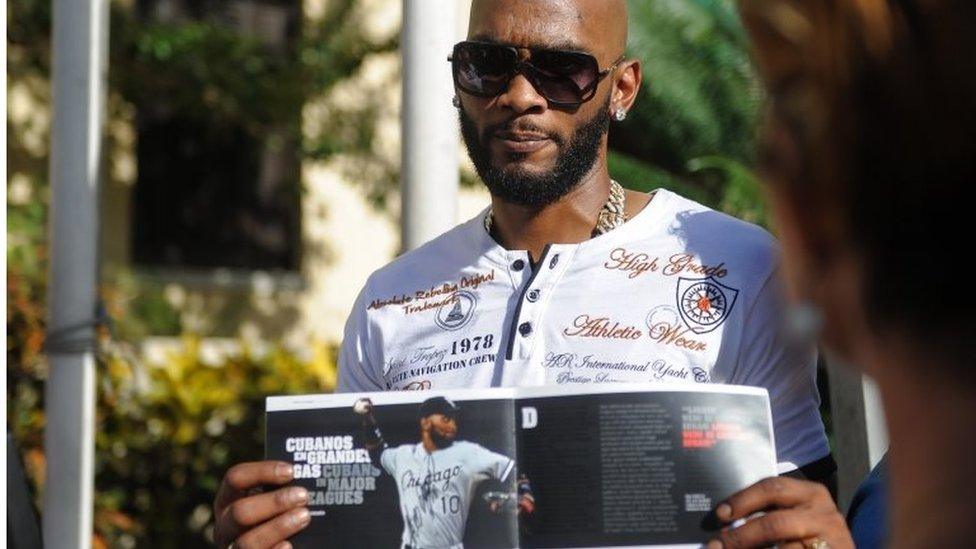 Cuban MLB player Alexei Ramirez shows a magazine before a press conference at the National Hotel in Havana, on December 15, 2015